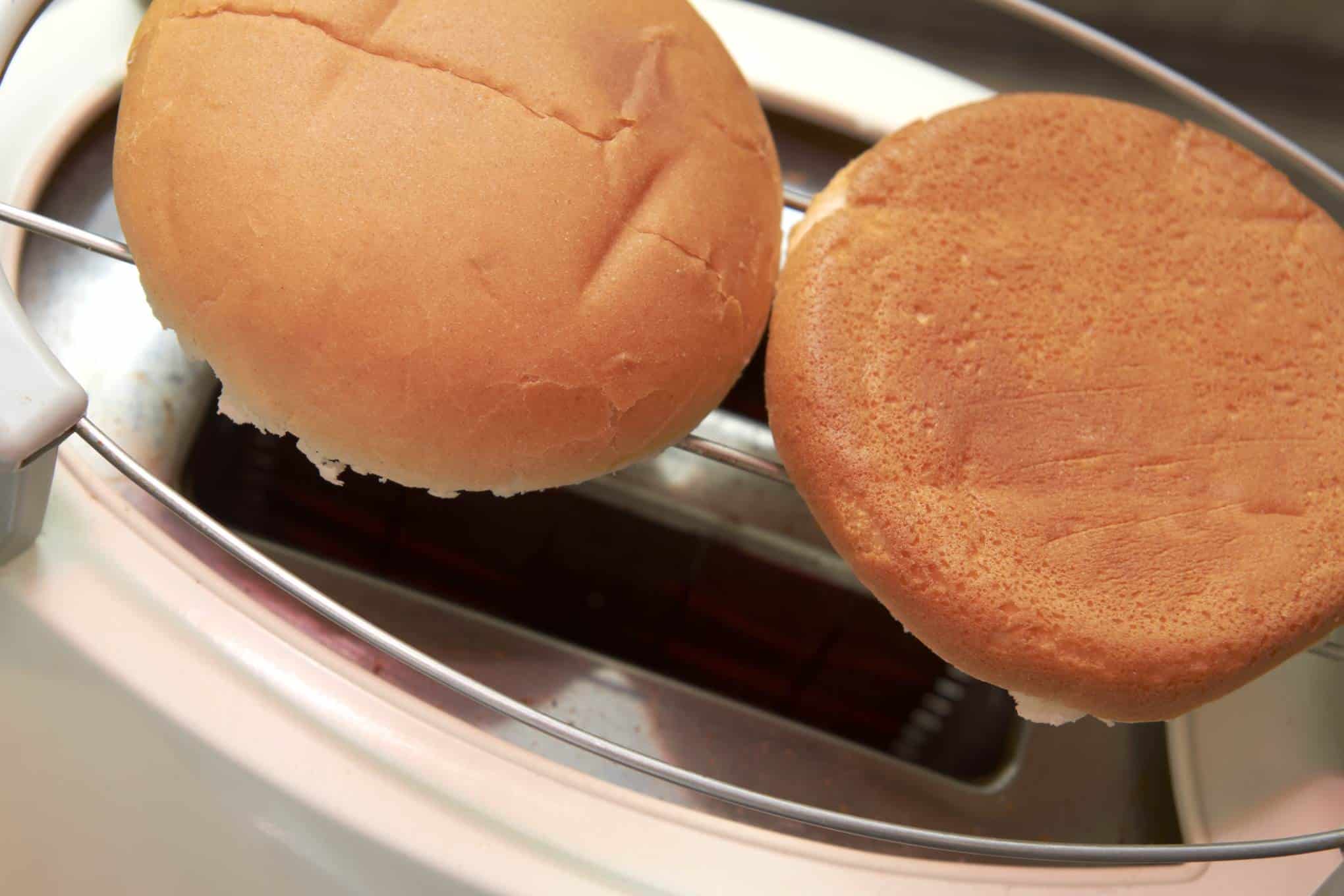 Leivänpaahdin, jonka päällä on kaksi sämpylänpuolikasta.