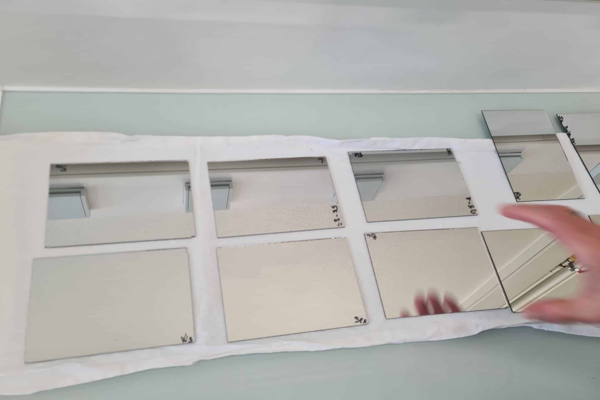 Useita pieniä peilejä ja henkilön käsi.