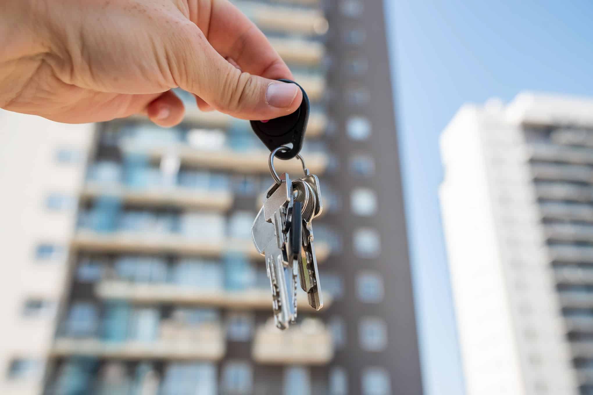 Henkilöllä on kädessään avainnippu.