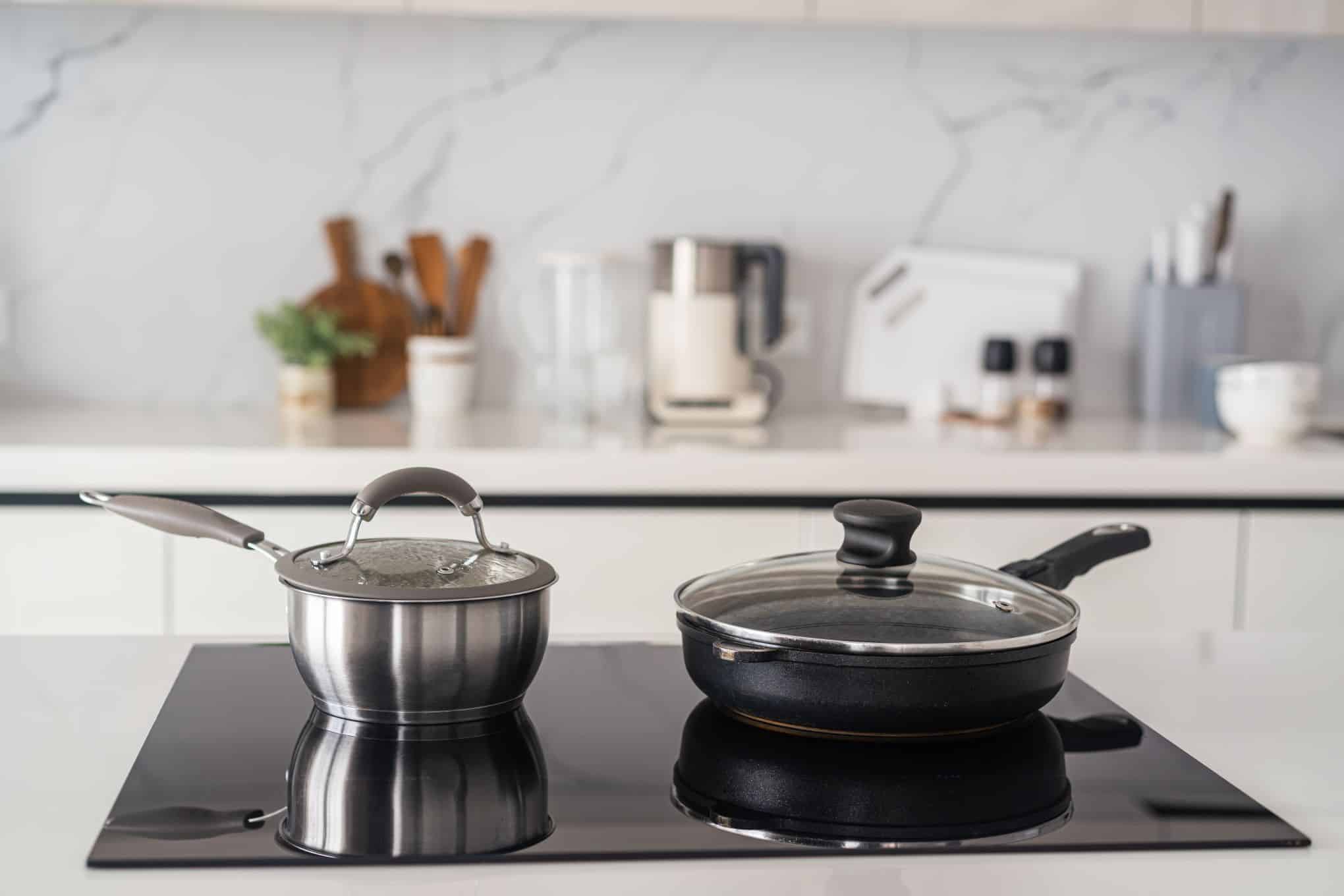 Keittiössä on induktiotaso, jonka päällä on pannu ja kattila.