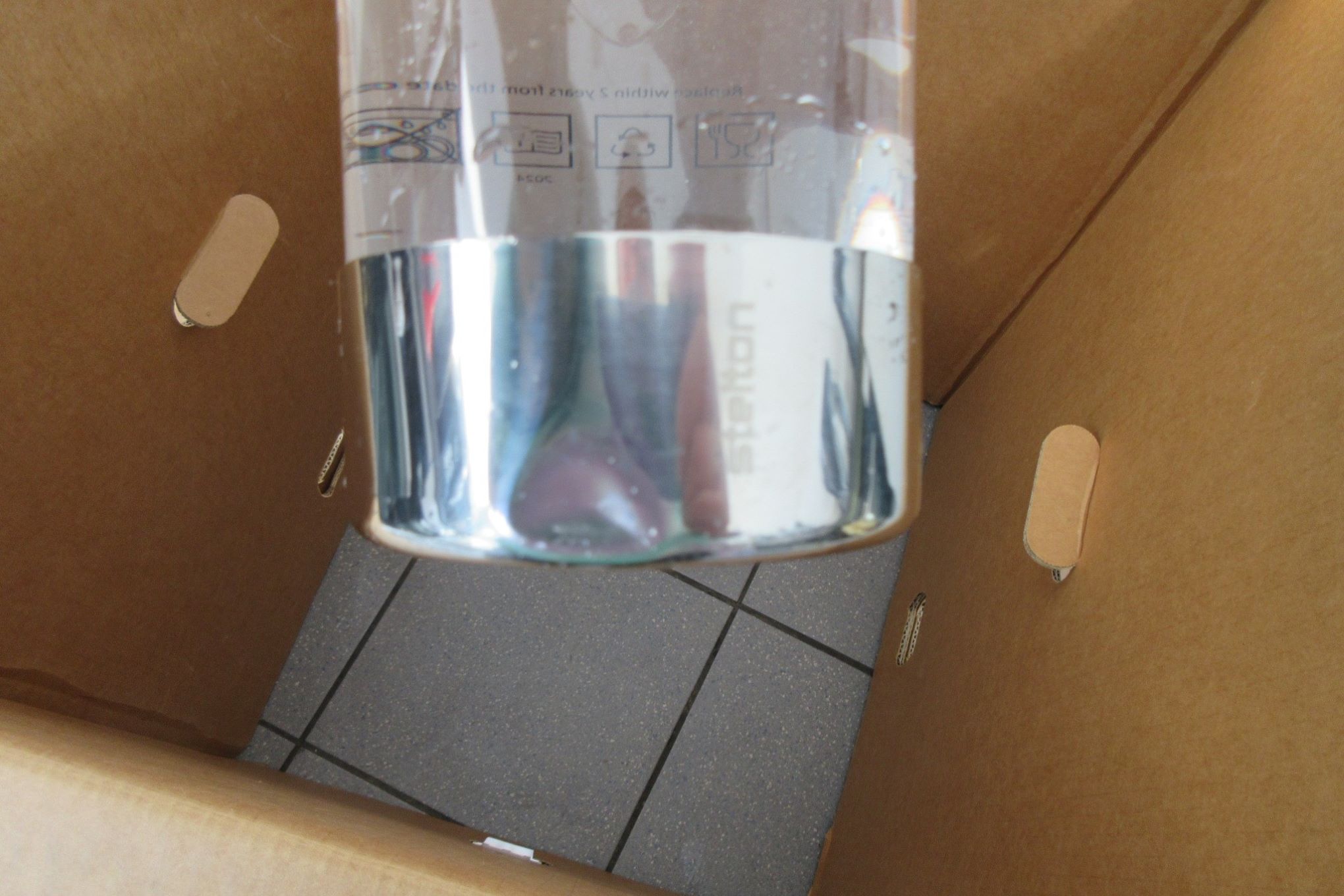 Hiilihapotuslaitteen pullo, jossa on lommo.