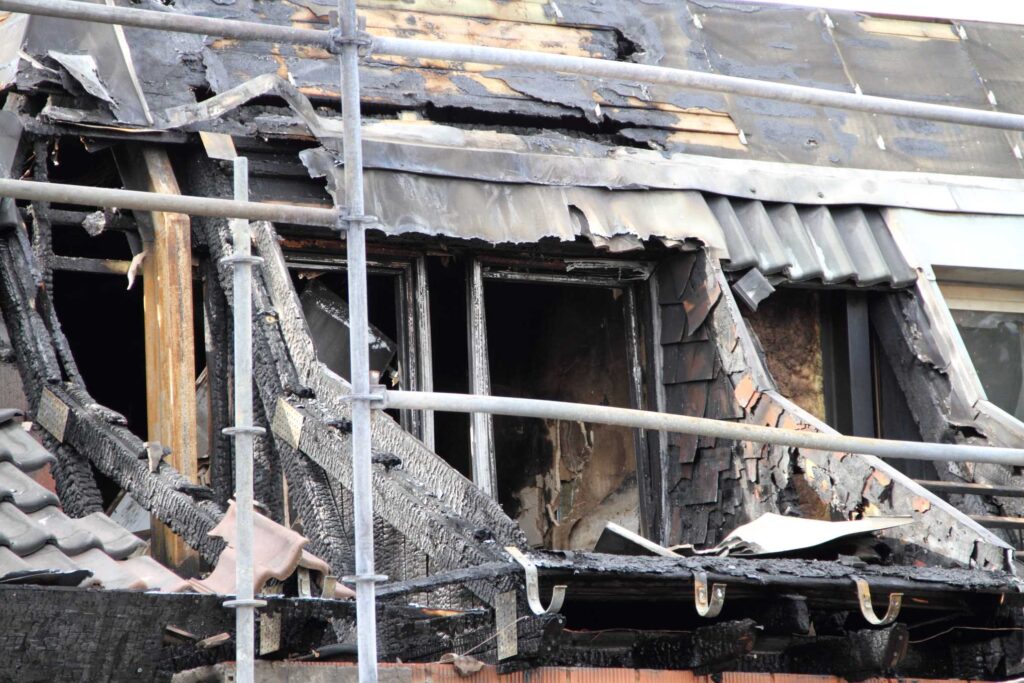 Palanut talo, jonka edessä on rakennusteline.