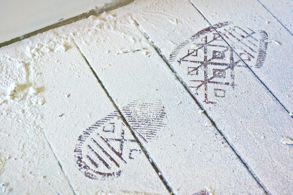 Kengänjälki pölyisellä lattialla.