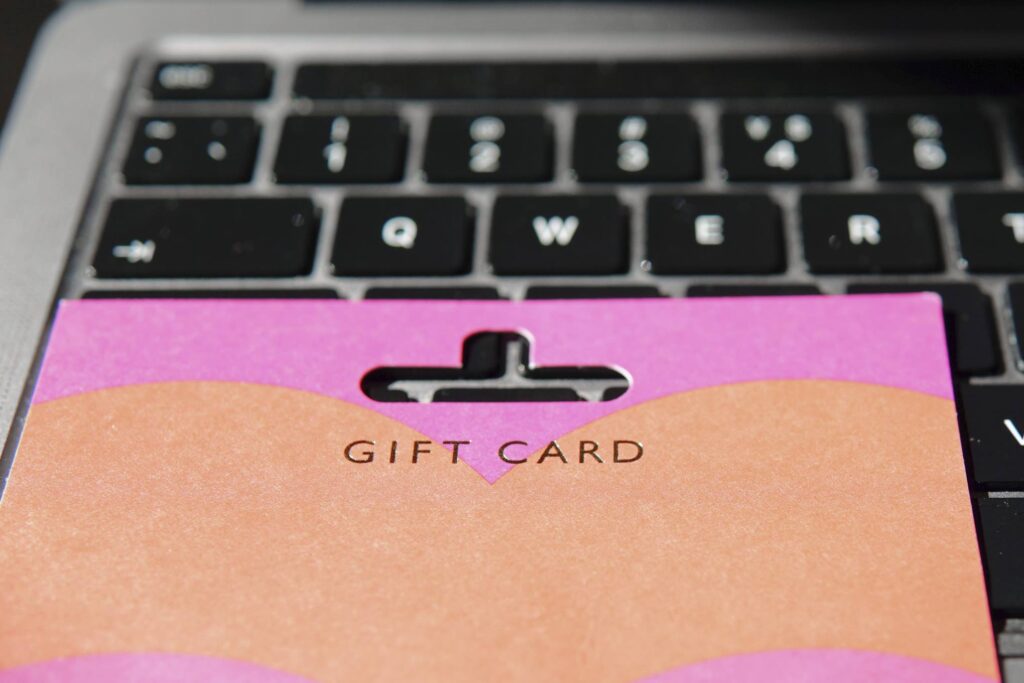 Tietokoneen näppäimistön päällä on lahjakortti.