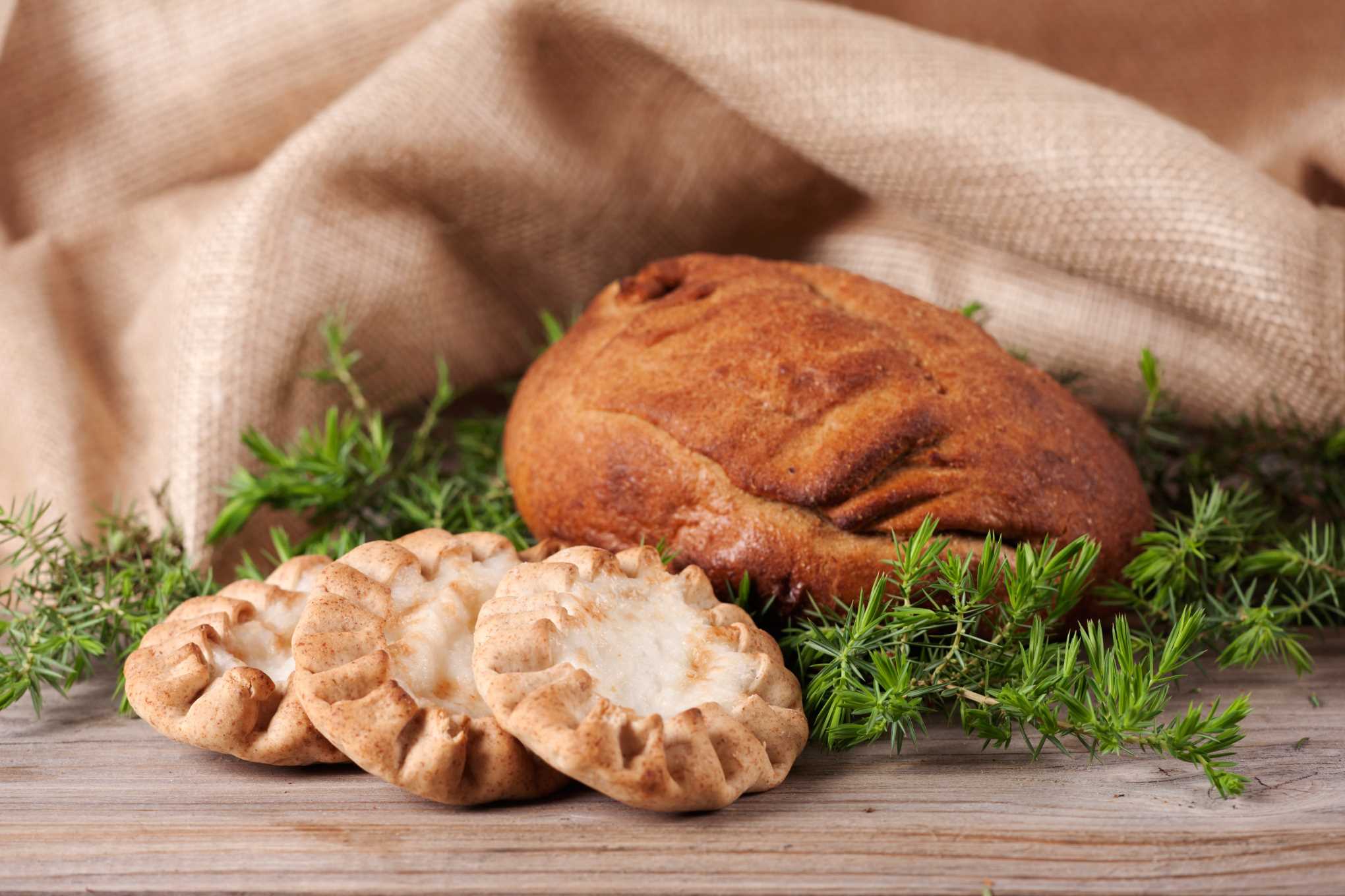 Pöydällä on kangasliina, karjalanpiirakoita ja kalakukko.