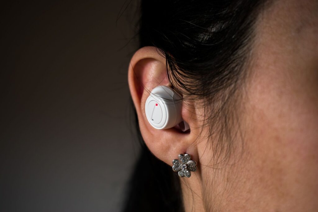 Henkilöllä on korvassaan langaton kuuloke.