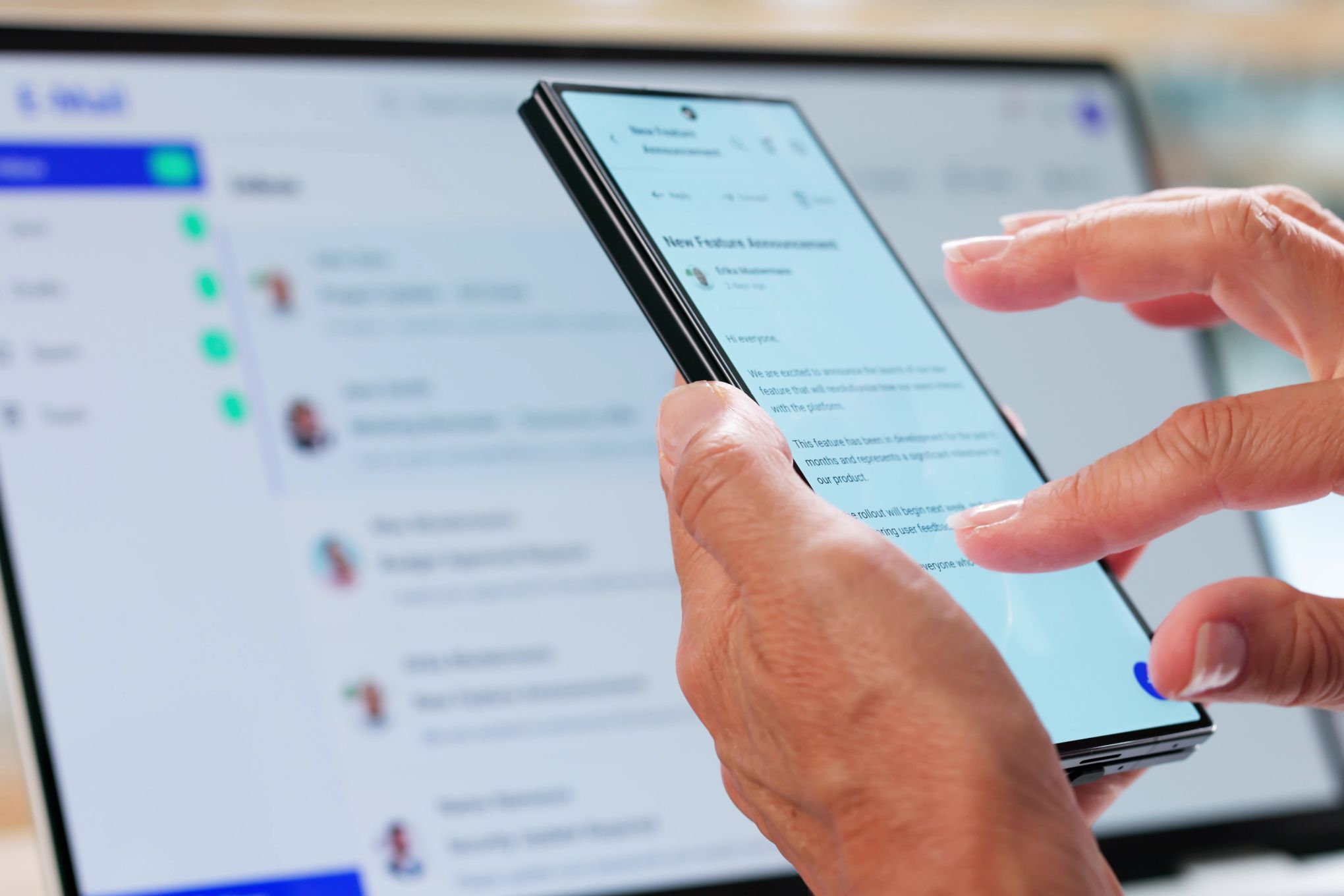 Henkilö käyttämässä puhelinta ja tietokonetta.