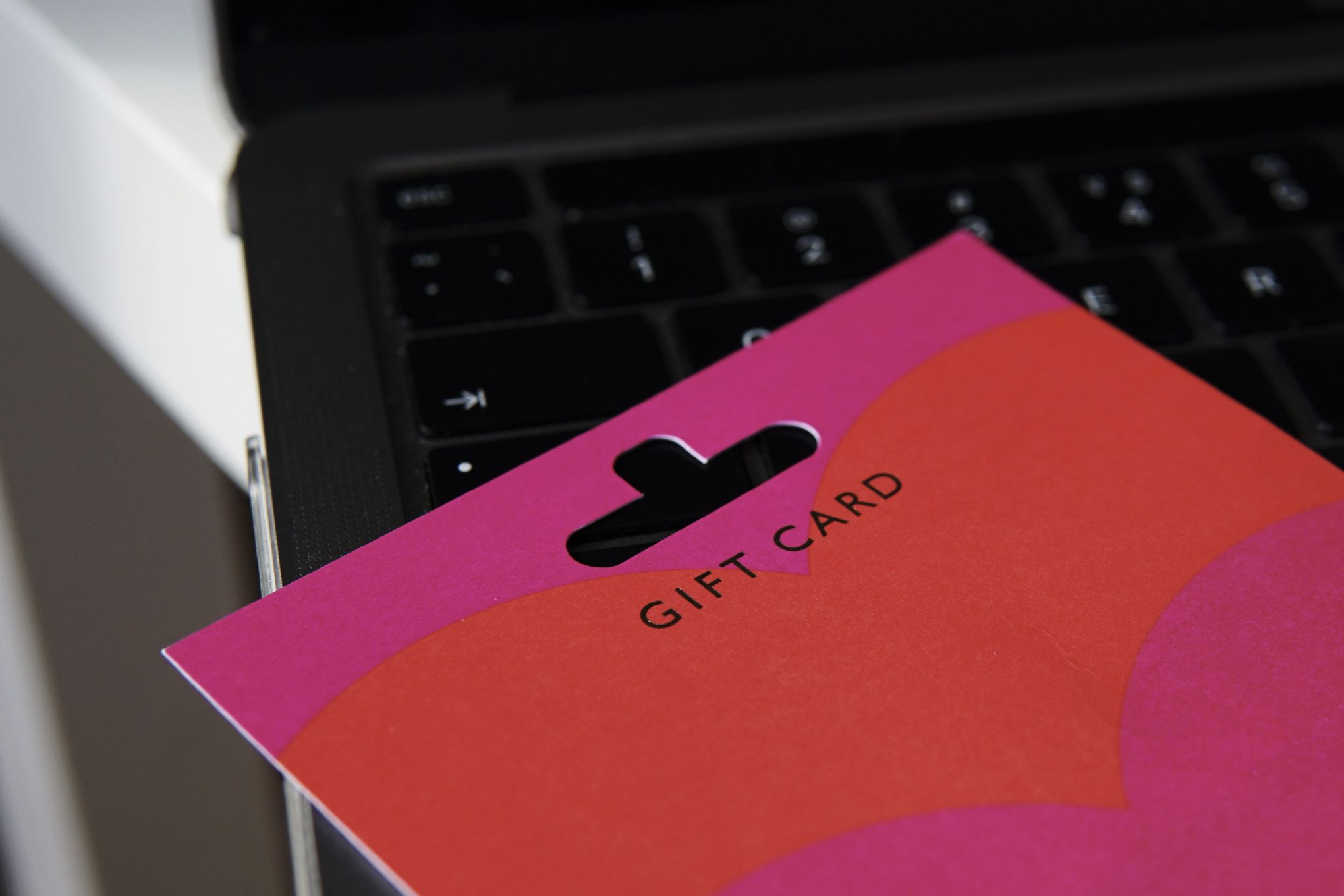 Tietokoneen päällä on lahjakortti.