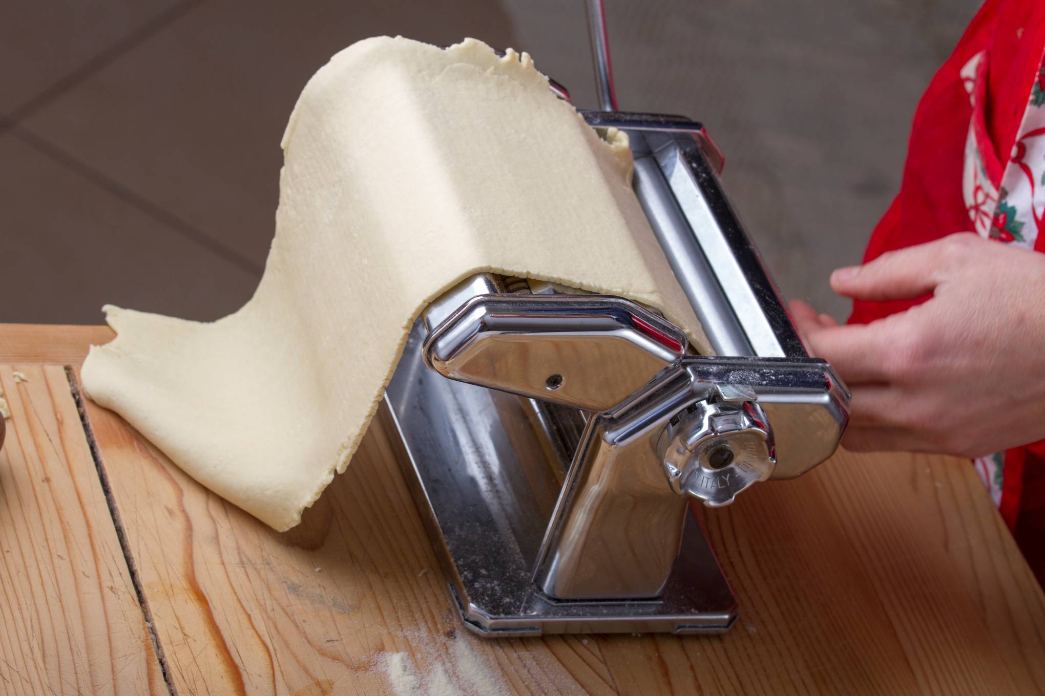 Henkilö käyttämässä pastakonetta.