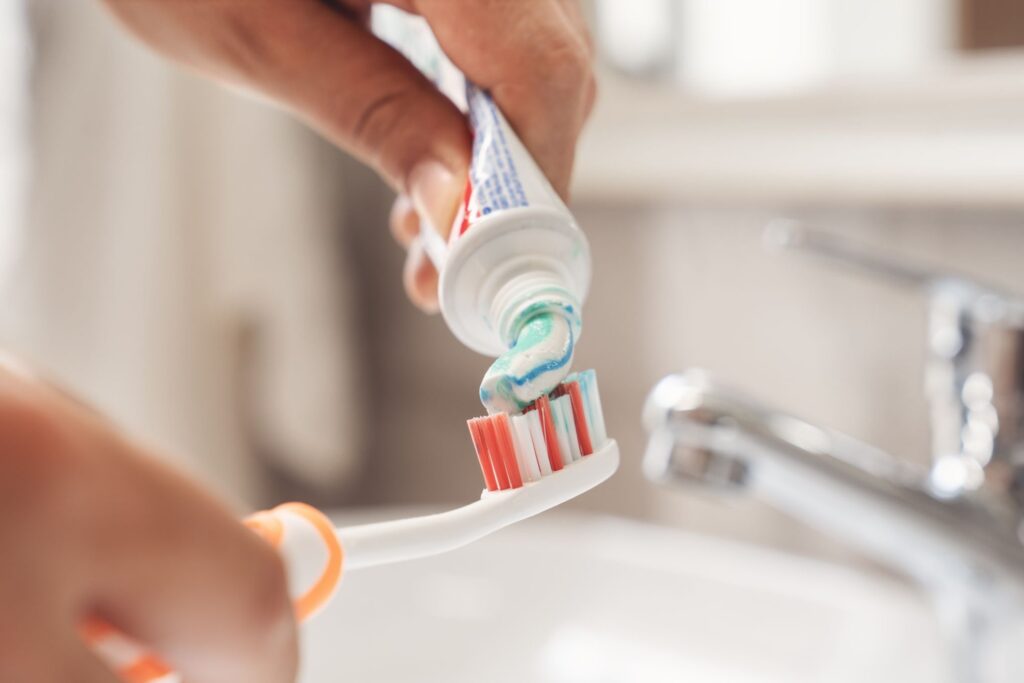 Henkilö levittämässä hammastahnaa hammasharjalle.